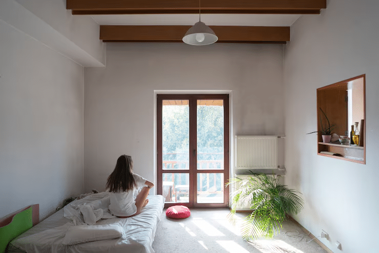 Small Indian bedroom with neutral wall color and sunlit accent wall