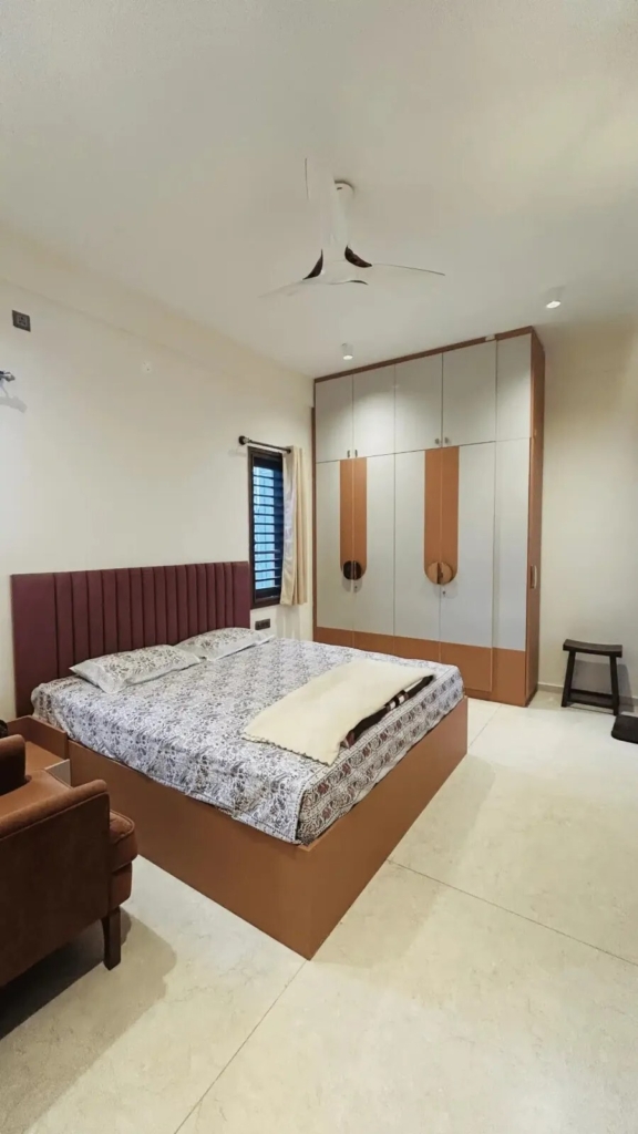 Contemporary master bedroom with custom wardrobes and elegant burgundy headboard designed by Elegante Interiors