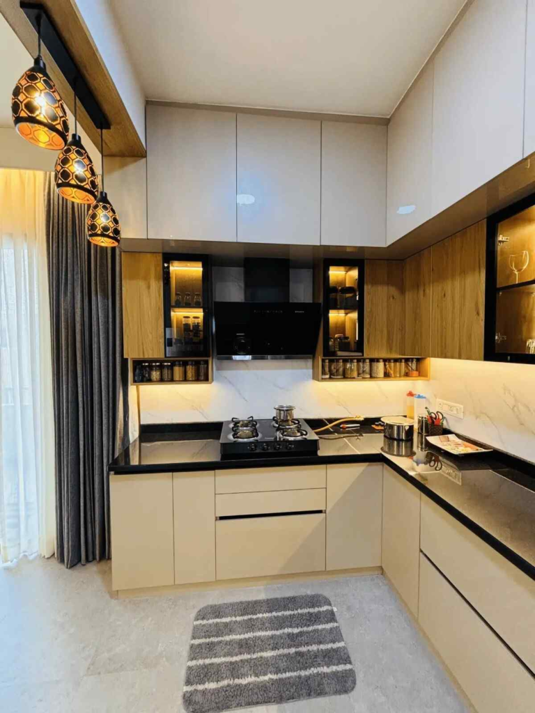 Modern modular kitchen with U-shaped layout, pendant lighting, and efficient storage solutions by Elegante Interiors Bangalore