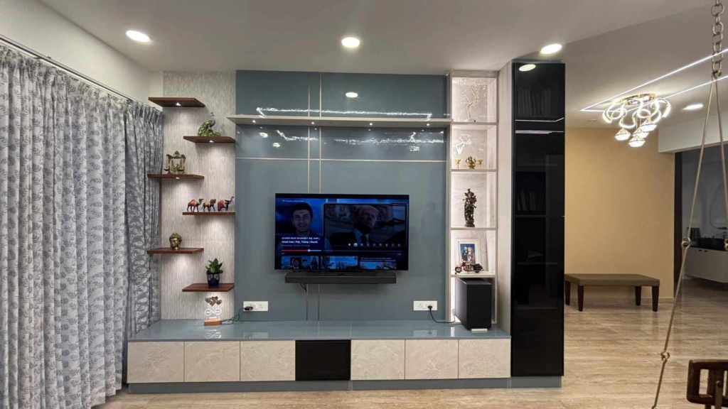 Luxury living room interior design Bangalore with custom TV unit, floating shelves and modern lighting by Elegante Interiors