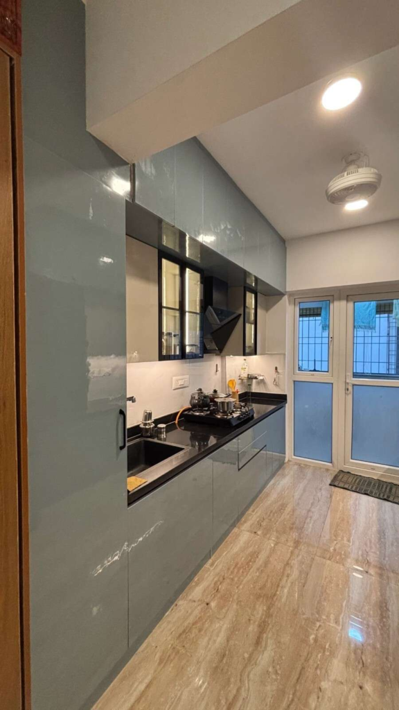 Modern modular kitchen interior design in Bangalore with sage green cabinets and black granite countertops by Elegante Interiors