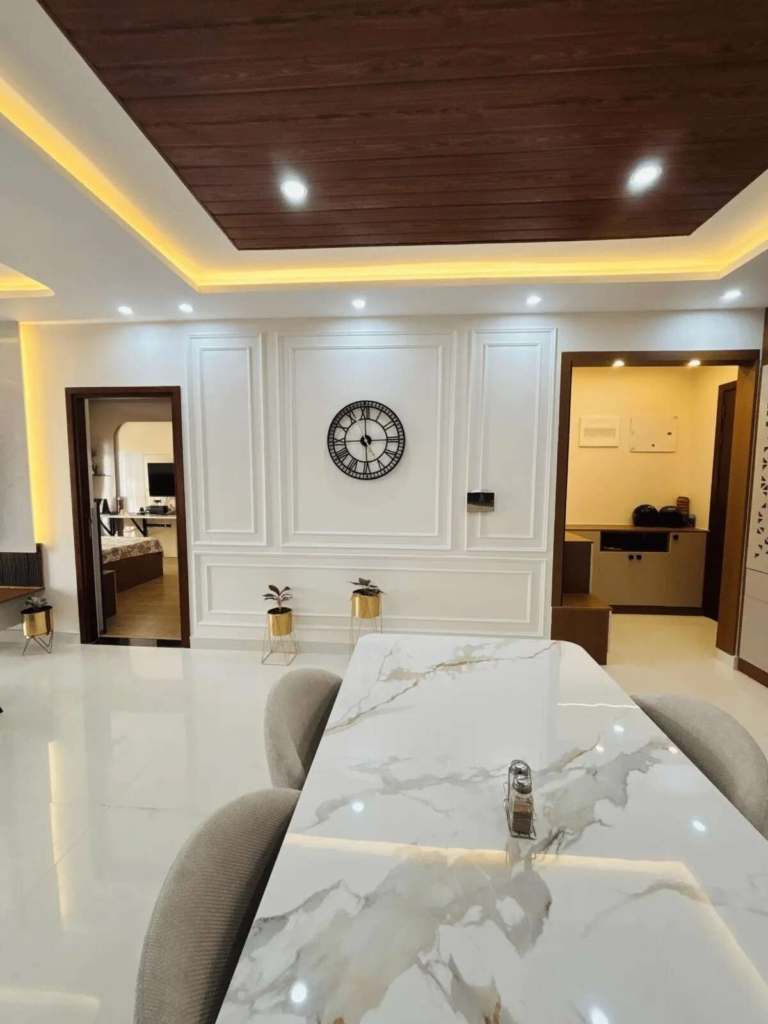 Contemporary apartment dining area with marble table and wooden ceiling design featuring ambient lighting