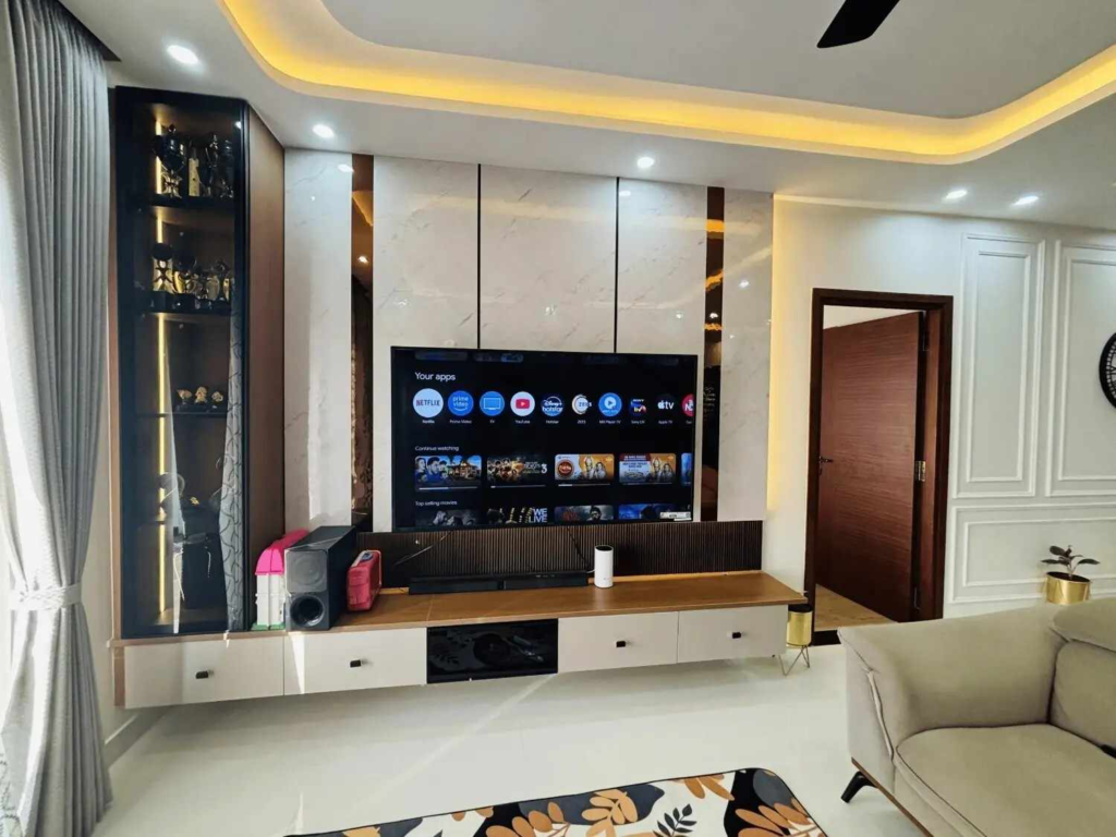 Modern living room entertainment wall with integrated TV mounting and illuminated display shelving