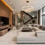 Best luxury interior designer in Bangalore showcasing a premium villa living room with Makrana marble flooring, teak veneer wall panels, designer furniture, and ambient lighting