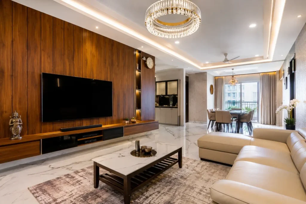 Luxury 3BHK apartment interior in Bangalore featuring Makrana marble flooring, teak veneer wall panels, Blum hardware cabinetry and premium false ceiling design